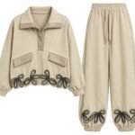 Costum Arhitectural Sport-Chic Two-Piece din Bluză cu Guler Polo și Detalii Florale cu Șnur, Asortată cu Pantaloni în Nuanță Bej Nisip / Warm Sand